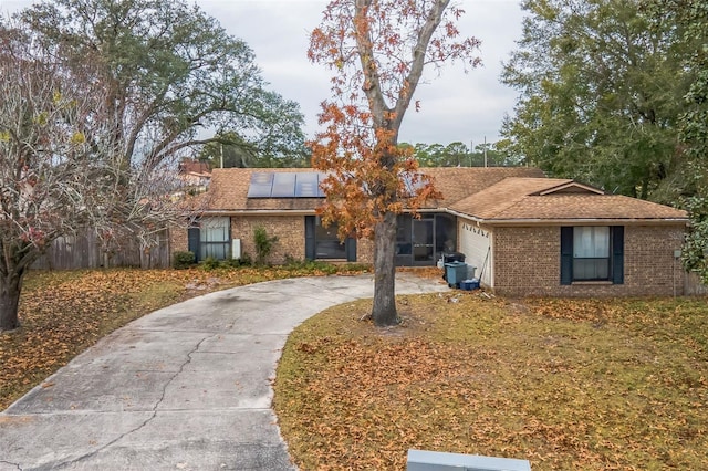 single story home featuring a garage, central AC unit, and solar panels