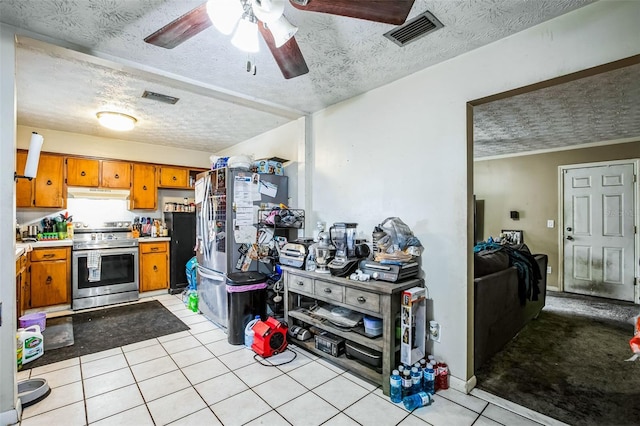 kitchen with a textured ceiling, light tile patterned floors, ceiling fan, and appliances with stainless steel finishes