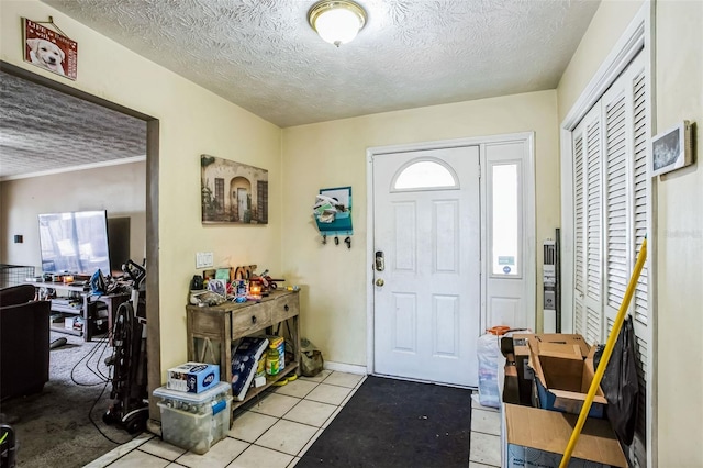 tiled entrance foyer with a textured ceiling