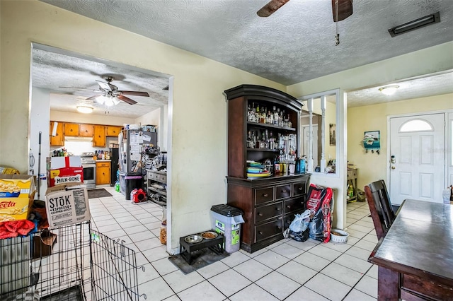 dining room with ceiling fan, a textured ceiling, and light tile patterned floors