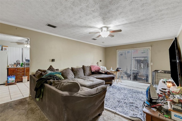 carpeted living room featuring ceiling fan, ornamental molding, and a textured ceiling