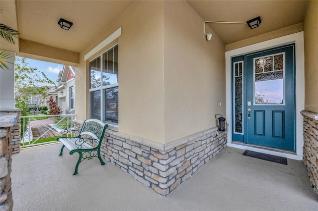 view of exterior entry featuring covered porch