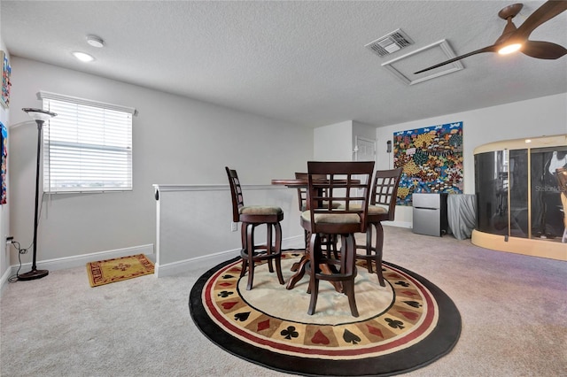 carpeted dining room featuring a textured ceiling