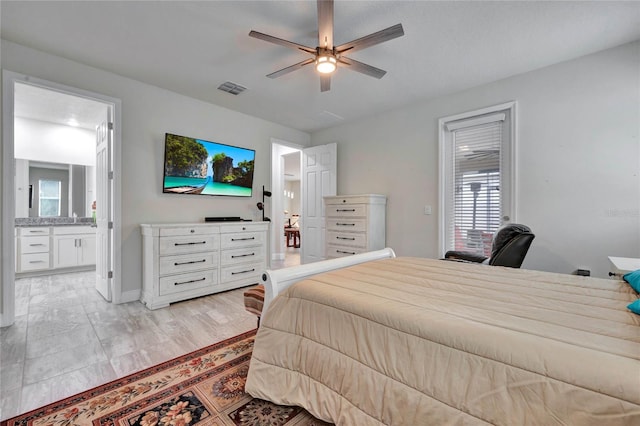 bedroom with ceiling fan, light hardwood / wood-style flooring, ensuite bathroom, and sink