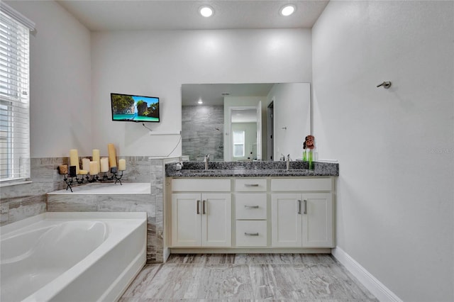 bathroom featuring a tub to relax in and vanity