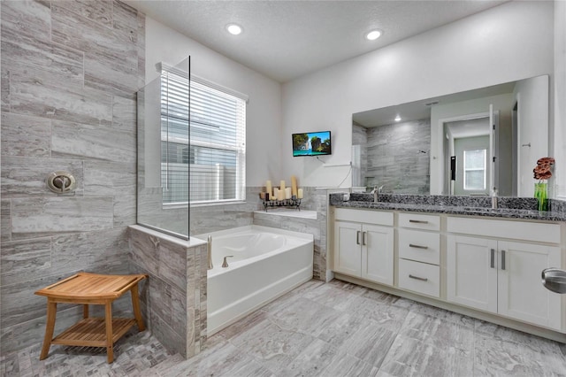 bathroom featuring separate shower and tub and vanity