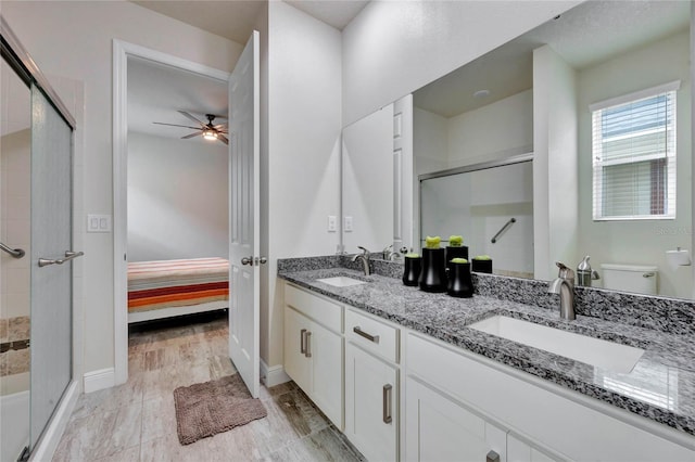 bathroom featuring vanity, ceiling fan, hardwood / wood-style floors, toilet, and a shower with shower door