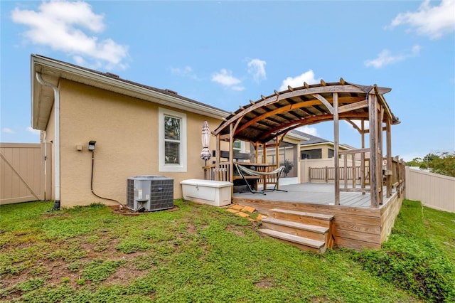 back of house with a yard, central AC unit, and a deck