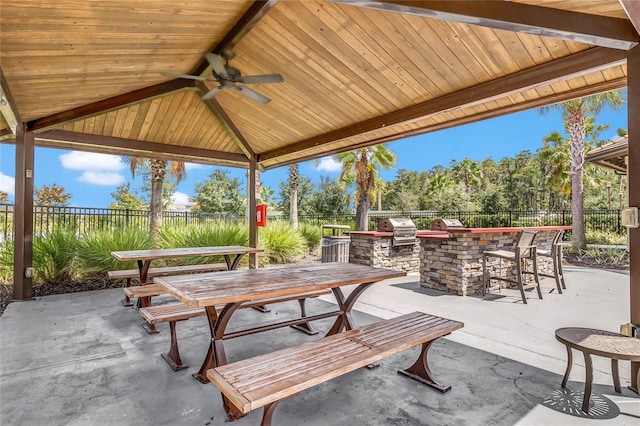 view of patio featuring a gazebo, ceiling fan, area for grilling, and exterior bar