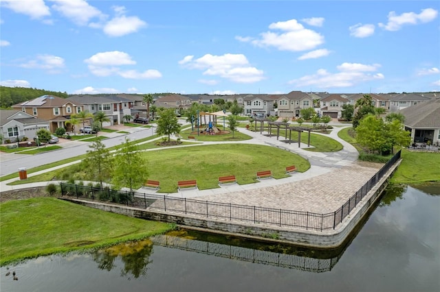 view of home's community with a water view and a lawn