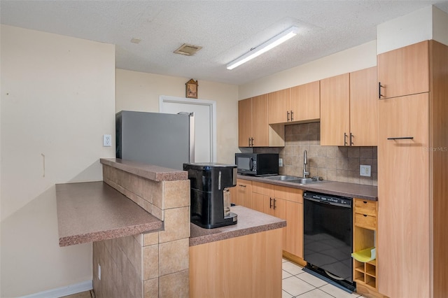 kitchen with sink, a textured ceiling, light brown cabinetry, light tile patterned floors, and black appliances