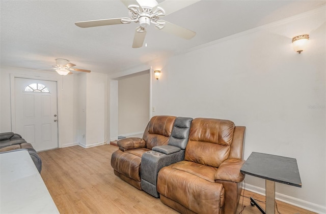 living room featuring light hardwood / wood-style flooring, ceiling fan, and ornamental molding