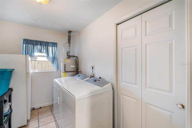 laundry area with light tile patterned floors, a textured ceiling, separate washer and dryer, and water heater