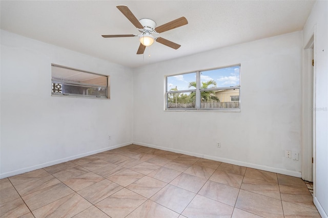 tiled empty room featuring ceiling fan