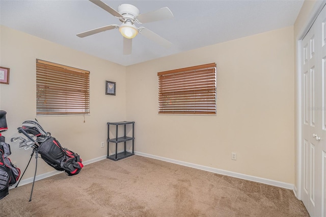 interior space featuring light carpet and ceiling fan