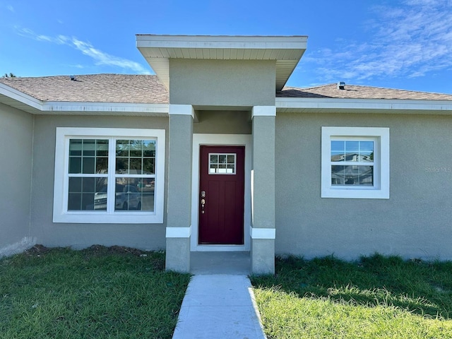 view of exterior entry featuring a yard