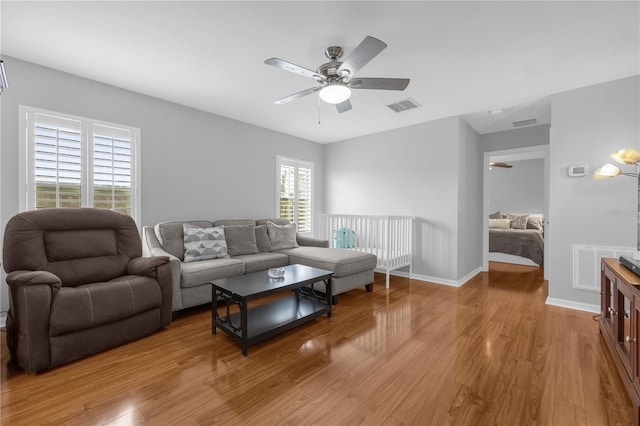 living room with ceiling fan and light hardwood / wood-style flooring