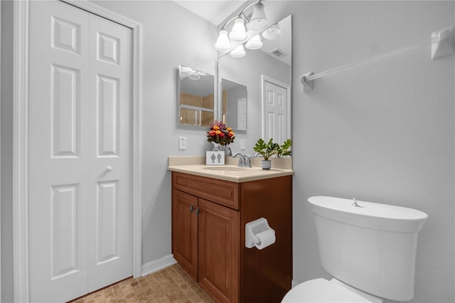 bathroom with vanity, toilet, and an inviting chandelier