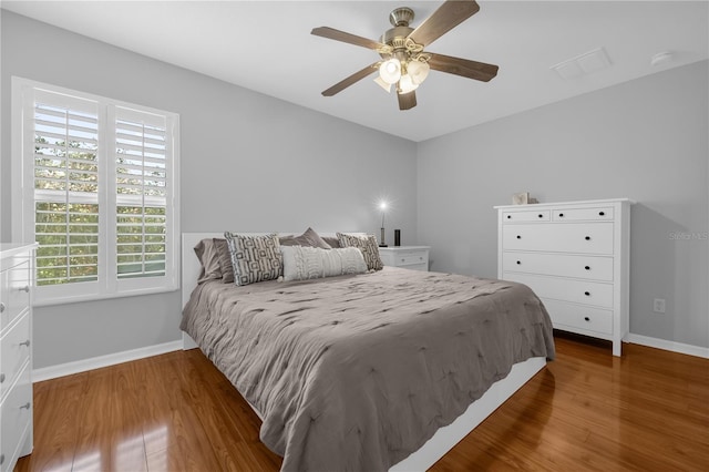 bedroom featuring multiple windows, ceiling fan, and dark wood-type flooring