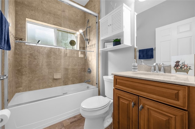 full bathroom featuring combined bath / shower with glass door, vanity, and toilet