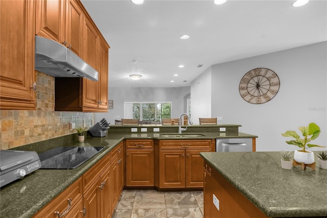 kitchen with tasteful backsplash, dark stone countertops, sink, and black electric stovetop