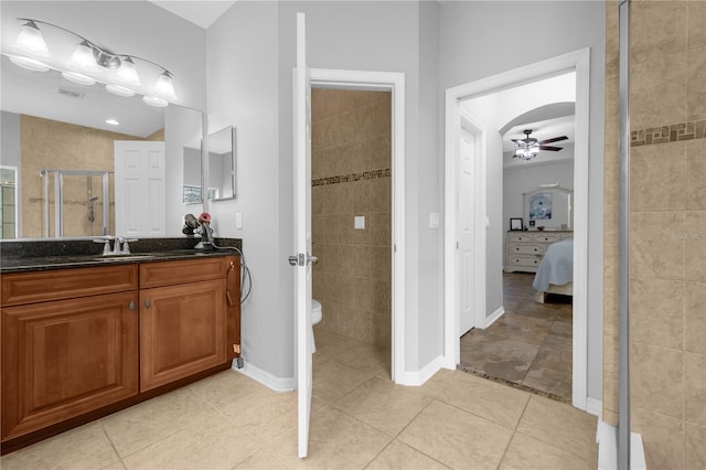 bathroom featuring ceiling fan, walk in shower, tile patterned flooring, toilet, and vanity