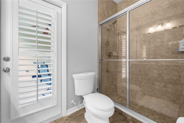 bathroom with an enclosed shower, toilet, and tile patterned floors