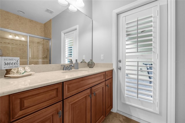 bathroom featuring tile patterned flooring, vanity, and an enclosed shower