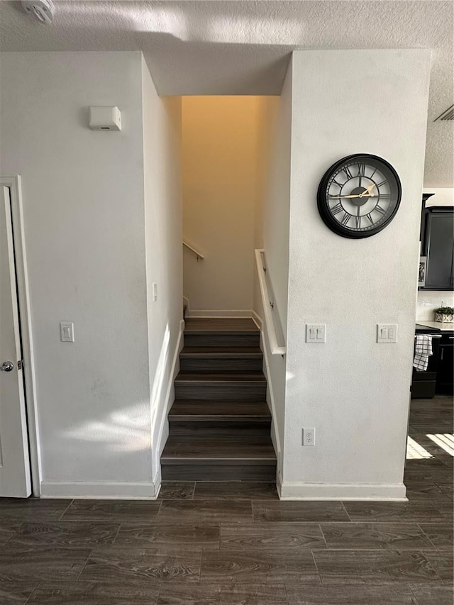 stairs with a textured ceiling