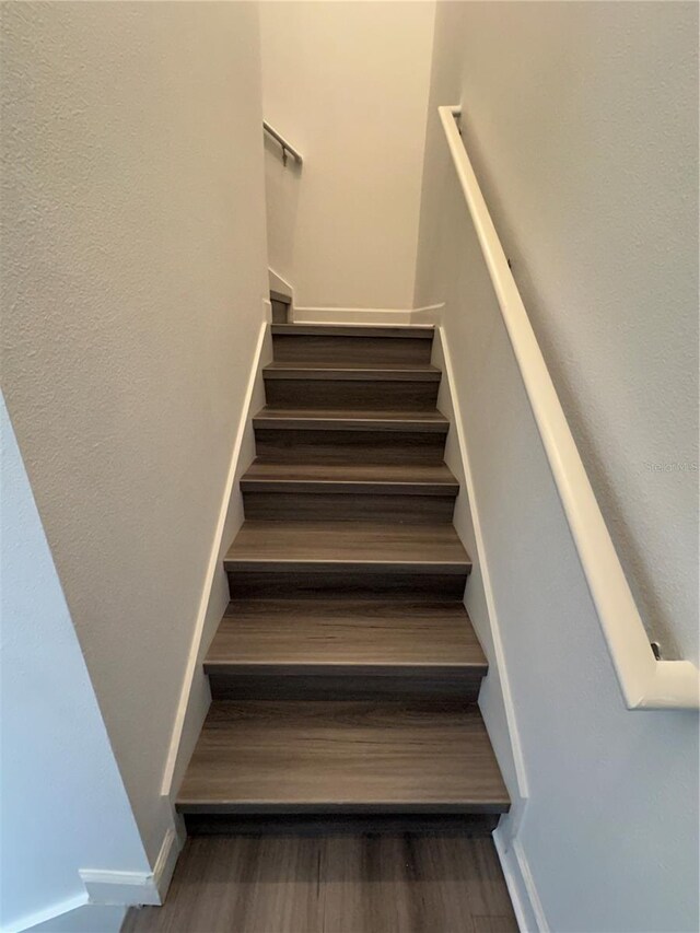 staircase with hardwood / wood-style flooring