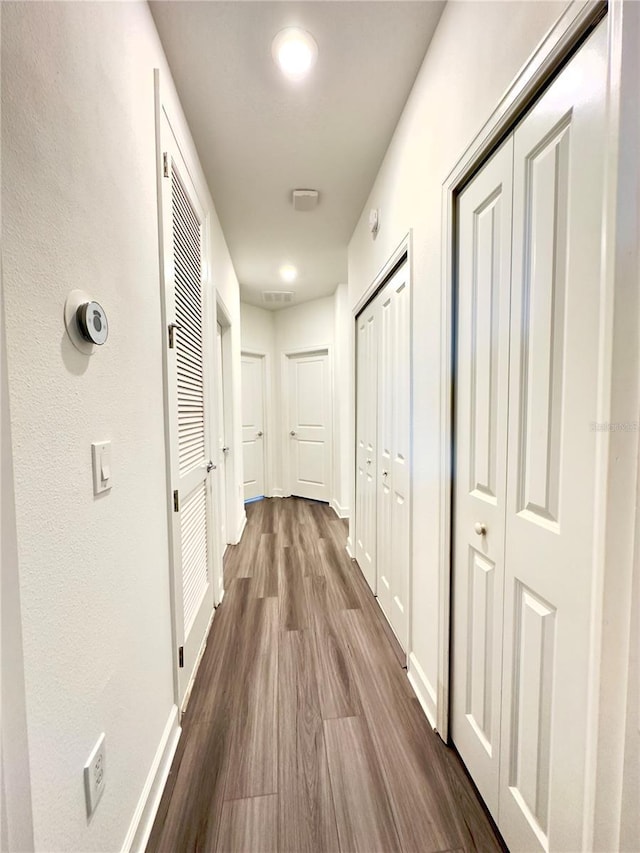 corridor with hardwood / wood-style floors