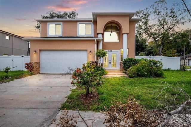 view of front of house featuring a yard, french doors, and a garage