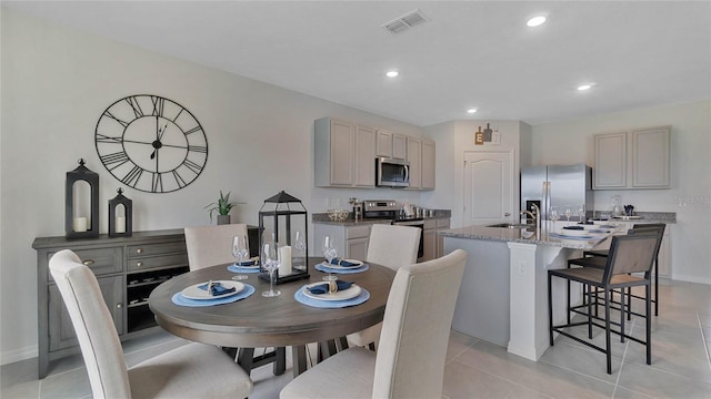 dining space featuring light tile patterned floors and sink