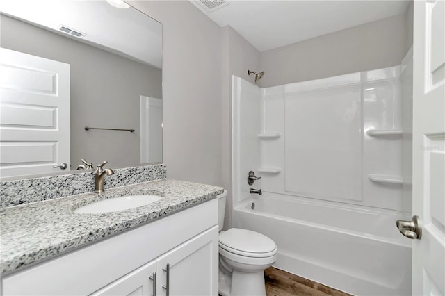 full bathroom with hardwood / wood-style floors, vanity, toilet, and  shower combination