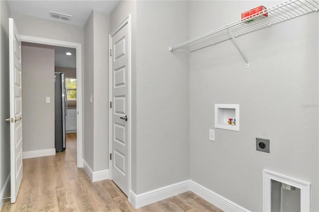 laundry area featuring electric dryer hookup, light hardwood / wood-style floors, and hookup for a washing machine