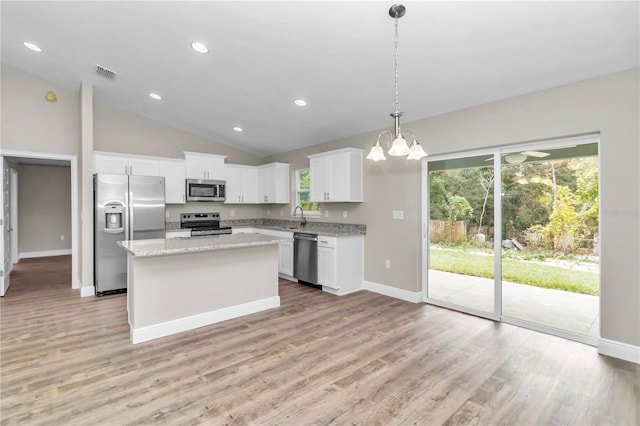 kitchen with a center island, white cabinets, sink, appliances with stainless steel finishes, and decorative light fixtures