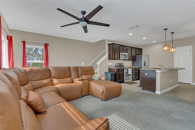 living room featuring light carpet, ceiling fan, and sink