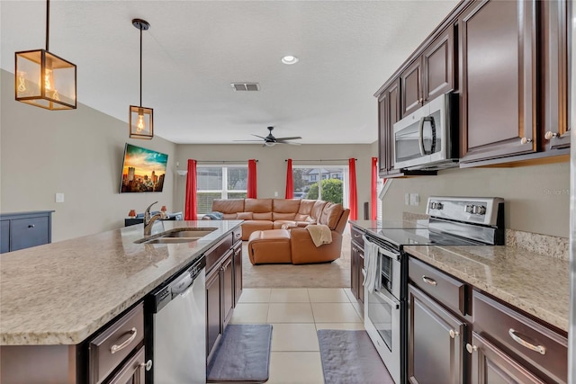 kitchen featuring dark brown cabinets, stainless steel appliances, ceiling fan, sink, and pendant lighting