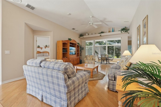 living room featuring light hardwood / wood-style floors, vaulted ceiling, and ceiling fan