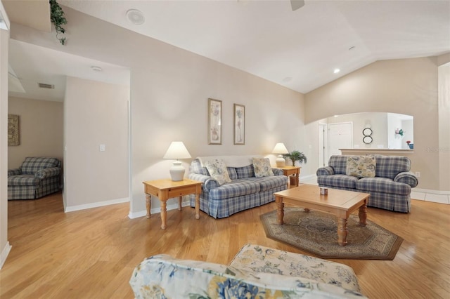 living room featuring light wood-type flooring and vaulted ceiling