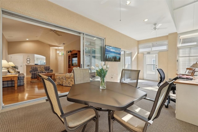 dining area featuring ceiling fan, carpet floors, and lofted ceiling