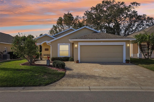 ranch-style house with a lawn, a garage, and central AC