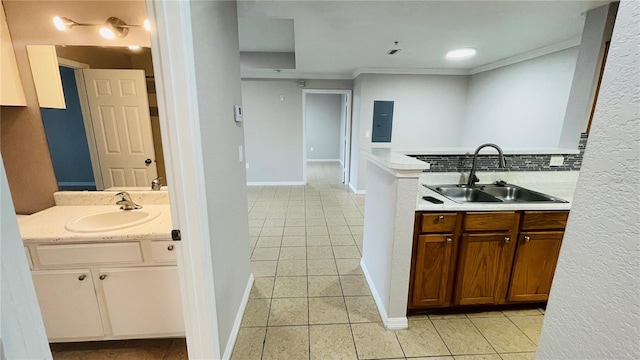 kitchen featuring backsplash, crown molding, sink, and electric panel