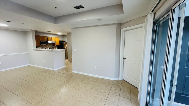 empty room with a raised ceiling and crown molding