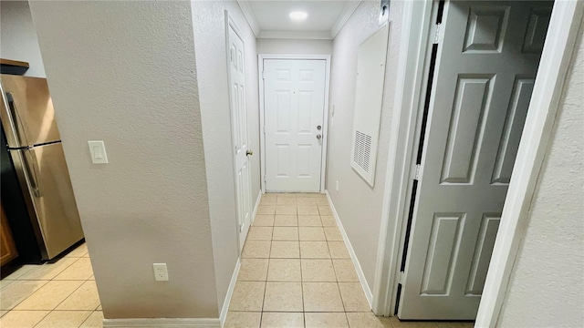 hallway with light tile patterned floors and ornamental molding