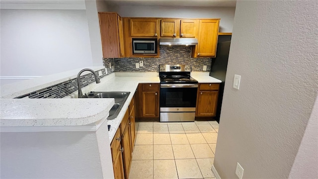 kitchen featuring sink, kitchen peninsula, decorative backsplash, light tile patterned floors, and appliances with stainless steel finishes