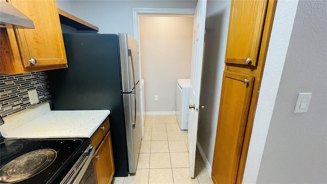 kitchen featuring backsplash, washer / clothes dryer, stove, extractor fan, and light tile patterned floors