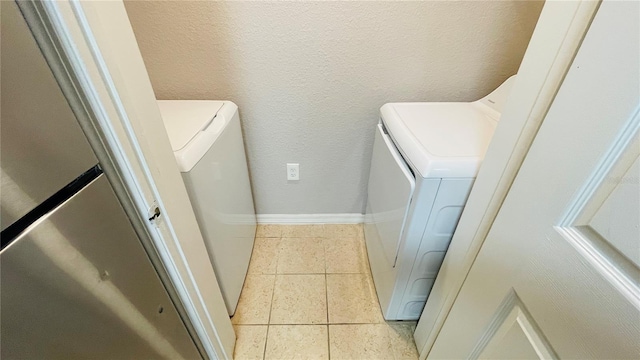 laundry area with light tile patterned floors and washer and dryer