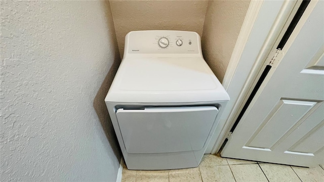 clothes washing area with light tile patterned floors and washer / dryer