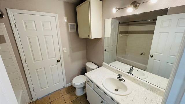 full bathroom with tile patterned flooring, vanity, tiled shower / bath combo, and toilet